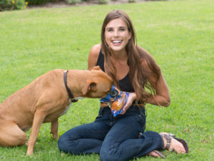 Girl with bag of dog treats, feeding a large dog 